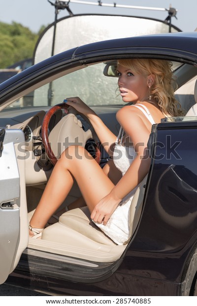 Pretty blond woman and luxury\
car