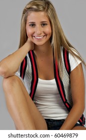 A Pretty Blond Young Teen Girl Sitting And Smiling.