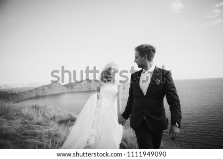 Pretty blonde bride and stylish groom on wedding day near the sea