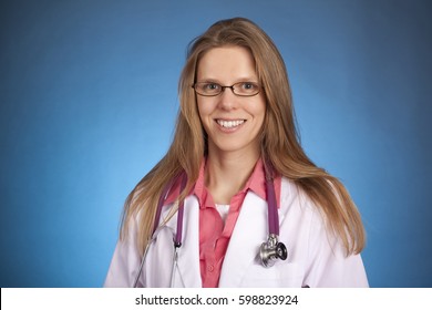 A Pretty Blonde Female Doctor Posing With A White Coat And Stethoscope On A Solid Background.