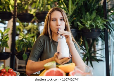 Pretty Blonde Fitness Girl Holding Fresh Milkshake Before Training, Diet Time Concept.