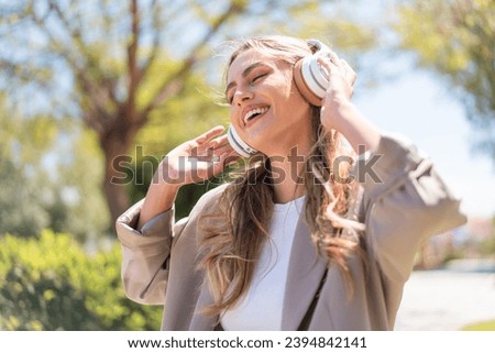 Pretty blonde Uruguayan woman listening music and singing