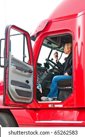 Pretty Blonde Woman In A Big Rig Talking On Her CB Radio To Other Truck Drivers.