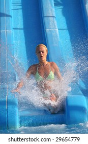 Pretty Blonde Woman Riding Down A Waterslide