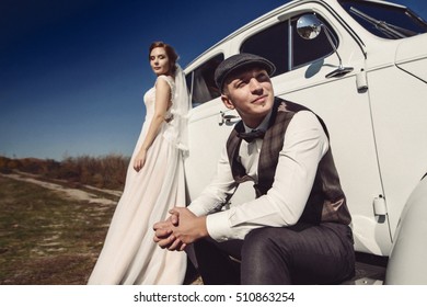 Pretty bride and handsome groom in the retro car