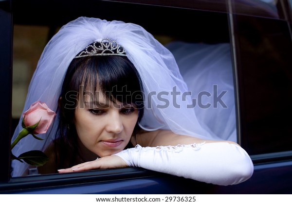 pretty bride with rose in\
car