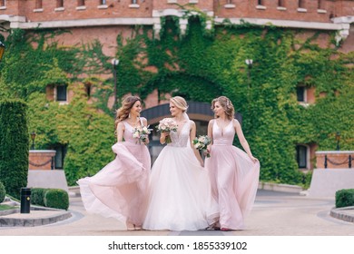 Pretty bridesmaids surround a bride holding wedding bouquets in their arms