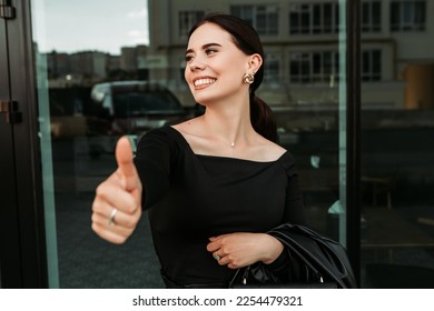 Pretty brunette caucasian woman standing outside street with white teeth beaming healthy smiling lady. Happy millennial girl showing thumb up like OK approve positive sign gesturing making faces

 - Shutterstock ID 2254479321