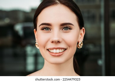 Pretty brunette caucasian woman standing outside street with white teeth beaming healthy smiling lady. Happy millennial girl model posing looking at the camera, head shot portrait.
 - Shutterstock ID 2254479323