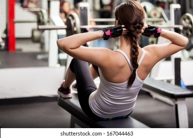 Pretty brunette doing crunches in front of a mirror in a gym - Powered by Shutterstock