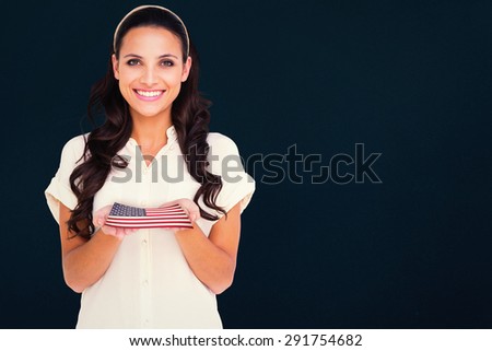 Pretty brunette holding out hands against blue background