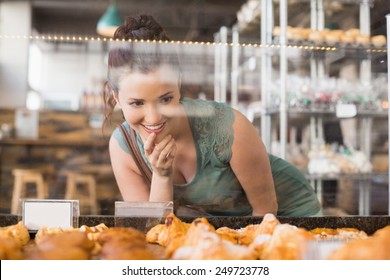 Pretty brunette looking at pastrys at the bakery - Powered by Shutterstock