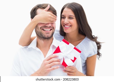 Pretty Brunette Surprising Boyfriend With A Gift On White Background