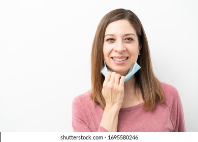 Pretty brunette taking her surgical mask off after coronavirus pandemic and looking happy - Powered by Shutterstock