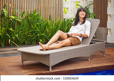 pretty brunette woman relaxing on a lounger outdoors - Powered by Shutterstock