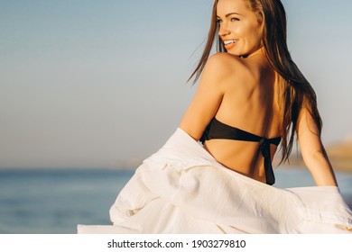 Pretty brunette woman relaxing on the beach at the sea