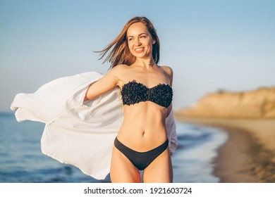 Pretty brunette woman relaxing on the beach at the sea