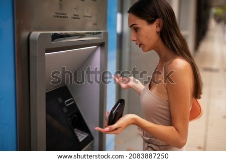 Pretty brunette woman withdraving cash. Young woman using ATM machine