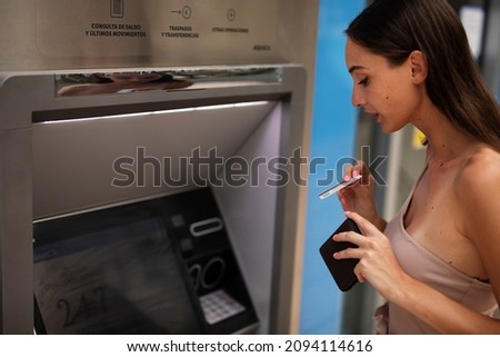 Pretty brunette woman withdraving cash. Young woman using ATM machine