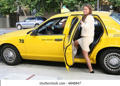 A Pretty Business Woman Getting Into A Taxi Cab