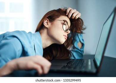 Pretty business woman with a tired look looks into the laptop - Shutterstock ID 1335299495