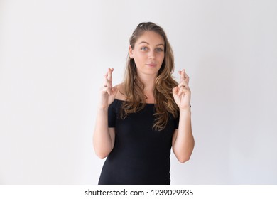 Pretty Caucasian girl crossing fingers in good luck gesture and looking at camera. Positive female manager having high expectations. Hoping for success concept - Shutterstock ID 1239029935