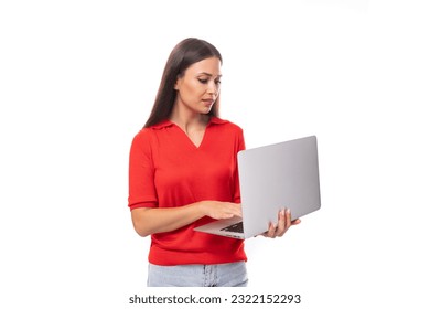 pretty caucasian woman with black hair dressed with a red v-neck blouse holding a laptop to work in the office
