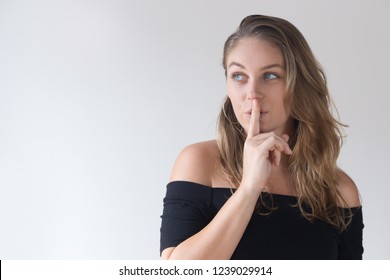 Pretty Caucasian Woman Holding Finger Near Mouth And Looking At Copy Space. Young Female Image Maker Sharing Beauty Tips. Secret Knowledge Concept