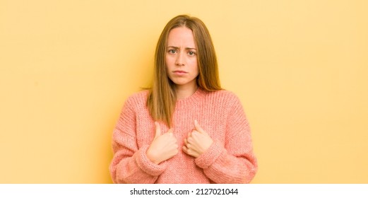 Pretty Caucasian Woman Pointing To Self With A Confused And Quizzical Look, Shocked And Surprised To Be Chosen