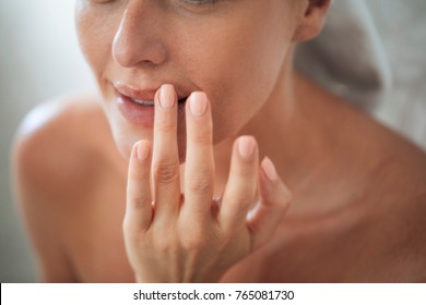 Pretty Caucasian Woman Putting Balm On Lips.