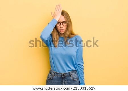 pretty caucasian woman raising palm to forehead thinking oops, after making a stupid mistake or remembering, 