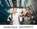 Pretty caucasian woman with suitcase and smartphone pressing button in elevator