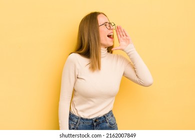 Pretty Caucasian Woman Yelling Loudly And Angrily To Copy Space On The Side, With Hand Next To Mouth