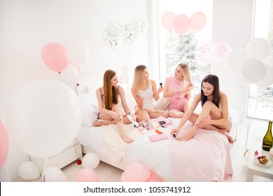 Pretty, charming, attractive, cheerful, slim, fashionable models enjoying meeting indoor, making make up, paint nails, combing out hair, applying balm on legs, preparing for event, talking, speaking