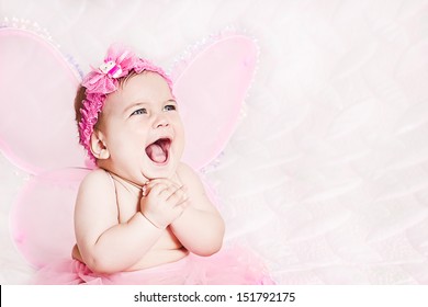 Pretty child girl in butterfly costume on pink