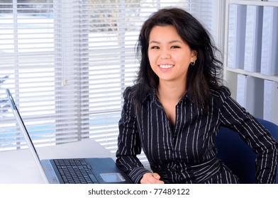 Pretty Chinese Business Woman With Long Hair Sat At Her Office Desk