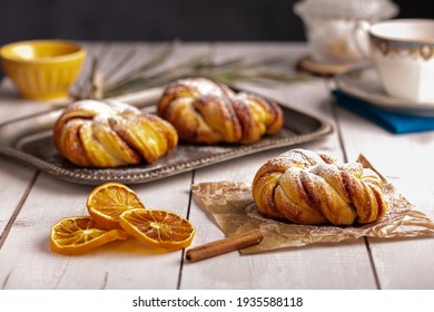 Pretty cinnamon knotted buns on a white wooden table