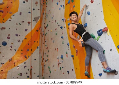 Pretty climber taking chalk powder from her bag when training - Powered by Shutterstock