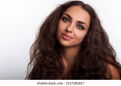 pretty and cute hispanic young woman with long brown hairstyle looking at camera and smile. Female model isolated portrait in studio on the white background