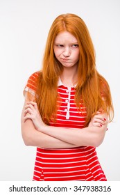 Pretty cute sad offended girl with beautiful red hair standing with hands crossed over white background