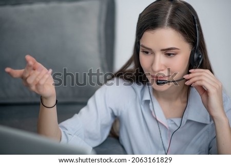 A pretty dark-haired operator of call canter working from home