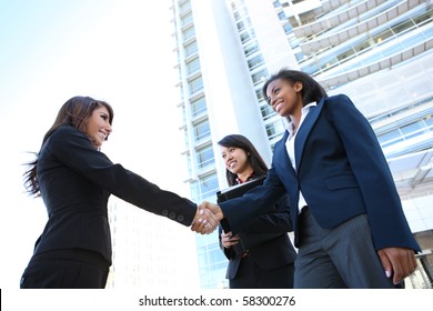 A pretty diverse young business woman team at office building handshake