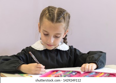 Pretty Elementary School Girl Working On Assignment In Classroom