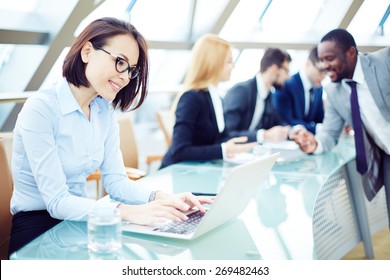 Pretty Employee Typing On Laptop In Working Environment