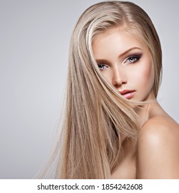 Pretty  face of young woman with long white hair - posing at studio over gray background