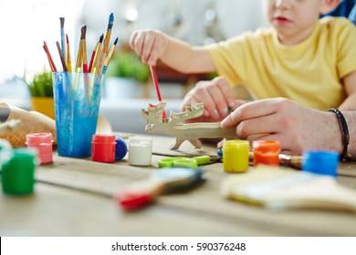 Pretty Family Of Two Attending Art Class And Working On Design Of Wooden Toy With The Help Of Brushes And Gouache, Close-up Shot