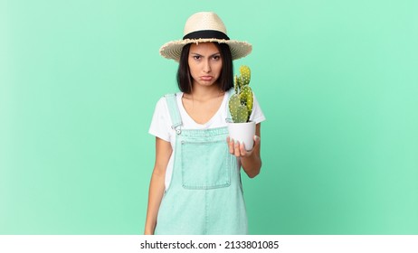 Pretty Farmer Woman Feeling Sad And Whiney With An Unhappy Look And Crying And Holding A Cactus