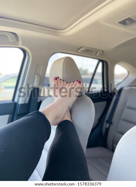Pretty feet hanging across\
the seat 