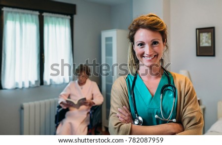 Pretty female doctor in a geriatric clinic with elderly woman in wheelchair