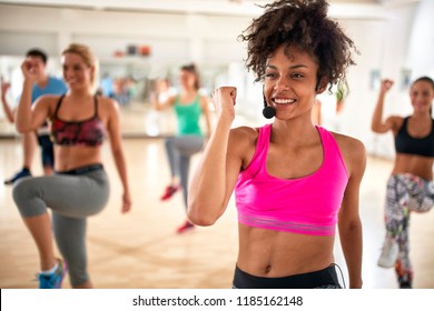 Pretty Female Instructor With Headset In Fitness Class Exercise With Group 